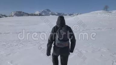 一个徒步旅行者在雪地里行走的轨道射击